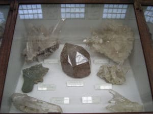 Une des vitrines consacrées au quartz, avec 4 spécimens de La Gardette, et peut être un autre d'Oisans (en haut à gauche). Notez les vitres d'époque.